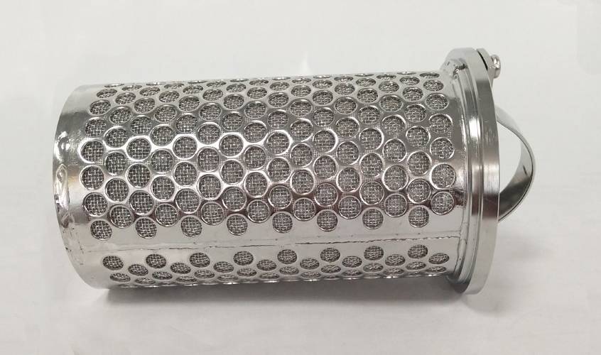 A perforated metal sintered filter basket is lying on the gray background.